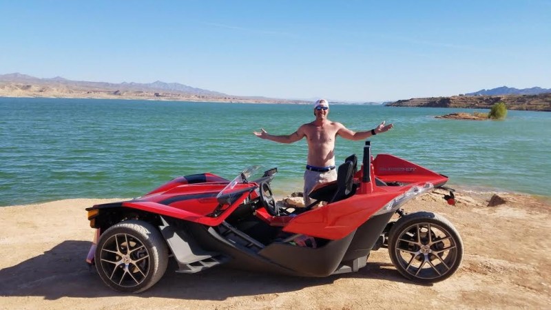 a person sitting on a motorcycle in front of a body of water