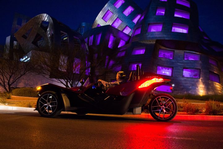 a person riding a motorcycle on display at night